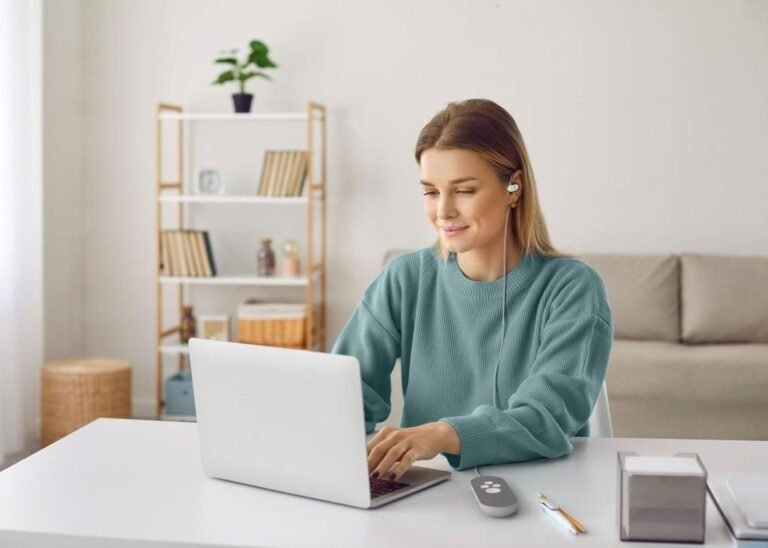 Person using a Nurosym vagus nerve stimulation device while working from home.