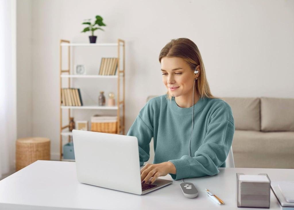 Person using a Nurosym vagus nerve stimulation device while working from home.