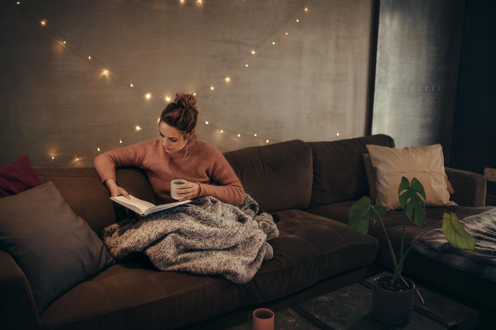 Person relaxing with a book in the evening as part of a healthy routine